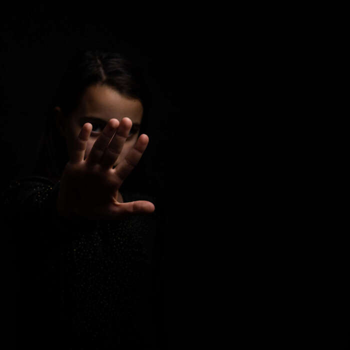 little girl with a raised hand making a stop sign gesture on a black background. Violence, harassment and child abuse prevention concept. little girl with a raised hand making a stop sign gesture on a black background. Violence, harassment and child abuse prevention concept