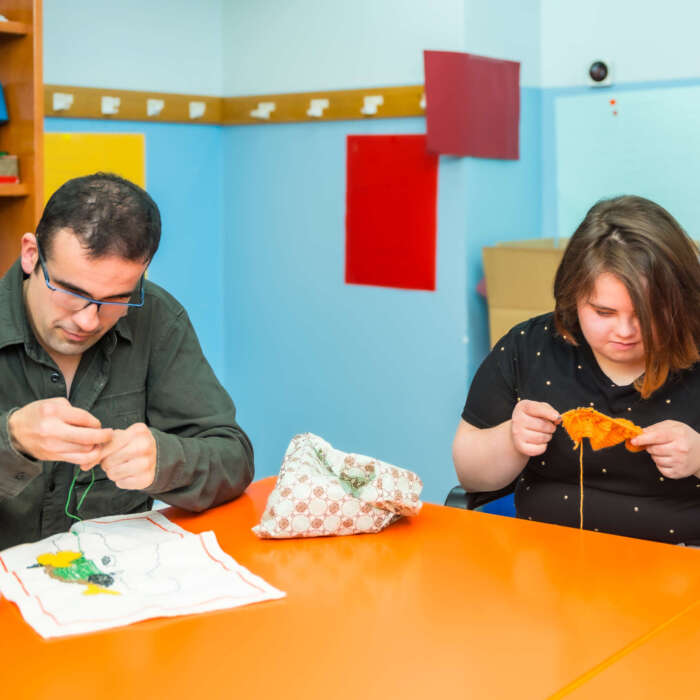 People with intellectual disabilities knitting clothes with wool People with intellectual disabilities knitting clothes with wool in a day care center